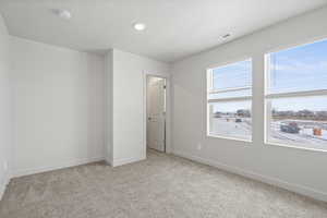 Unfurnished bedroom featuring light colored carpet