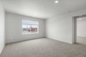 Carpeted empty room featuring a textured ceiling