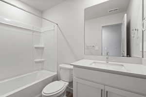 Full bathroom with toilet, vanity, and tub / shower combination