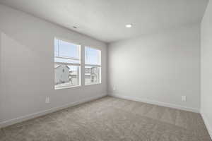 Carpeted spare room with a textured ceiling