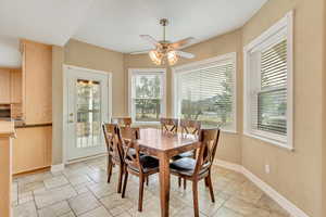 Dining space with ceiling fan and a healthy amount of sunlight