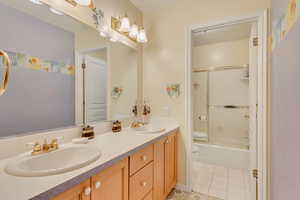 Full bathroom with tile patterned flooring, vanity, toilet, and enclosed tub / shower combo