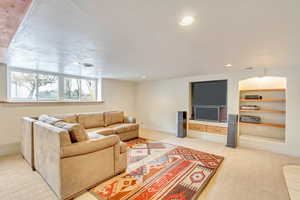 Living room featuring built in shelves and a textured ceiling