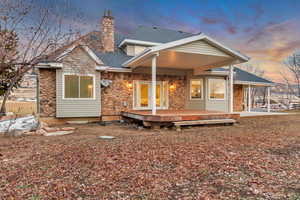 Back house at dusk with a wooden deck