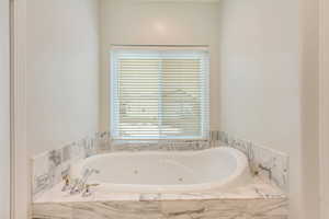 Bathroom with a healthy amount of sunlight and tiled tub