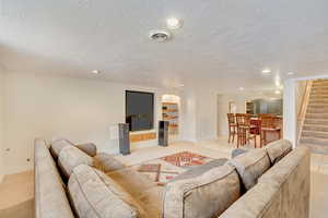 Tiled living room featuring a textured ceiling