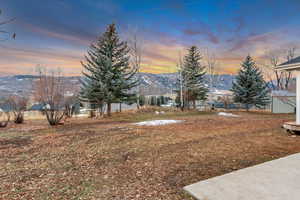 Yard at dusk featuring a mountain view