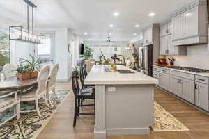 Kitchen with plenty of natural light, sink, stainless steel appliances, and a kitchen island with sink