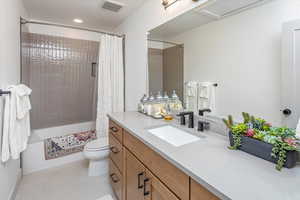 Full bathroom with vanity, toilet, and shower / bathtub combination with curtain