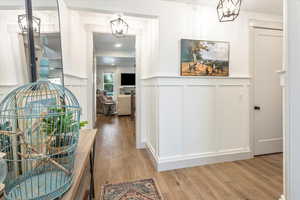 Hall featuring an inviting chandelier and light wood-type flooring