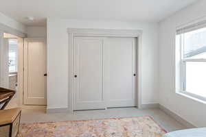 Bedroom featuring a closet, light carpet, and multiple windows