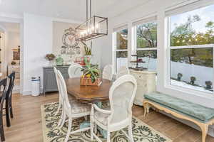 Dining area with a notable chandelier and light hardwood / wood-style flooring