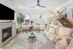 Living room with light hardwood / wood-style flooring and ceiling fan