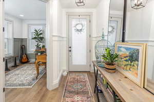 Entrance foyer featuring light hardwood / wood-style flooring and a notable chandelier