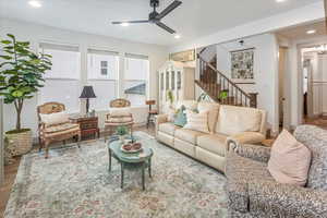 Living room featuring hardwood / wood-style floors and ceiling fan with notable chandelier