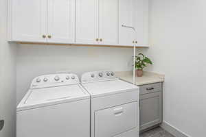 Washroom with cabinets and independent washer and dryer