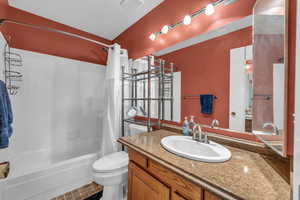 Full bathroom featuring toilet, tile patterned floors, vanity, and shower / tub combo with curtain