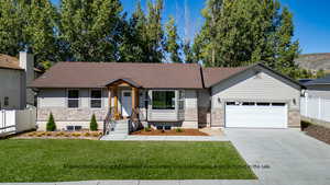 View of front of house with a mountain view, a front yard, and a garage