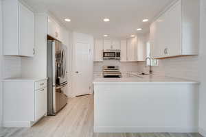 Kitchen featuring sink, white cabinetry, and stainless steel appliances