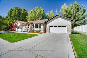 View of front of house with a garage and a front lawn