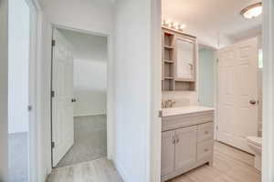 Bathroom featuring hardwood / wood-style floors, vanity, and toilet