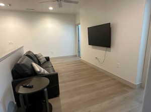 Living room with ceiling fan and light hardwood / wood-style flooring