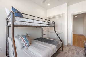 Bedroom with ceiling fan, a closet, and light hardwood / wood-style flooring