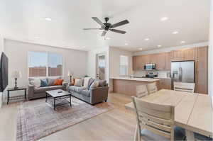 Living room featuring ceiling fan, light wood-type flooring, and sink