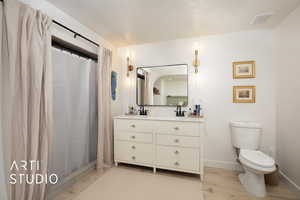 Bathroom with hardwood / wood-style flooring, vanity, toilet, and a shower with shower curtain