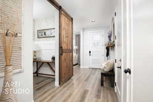 Hall featuring a barn door and light hardwood / wood-style flooring