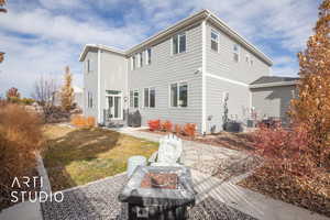 Rear view of property featuring a lawn and cooling unit