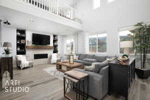 Living room with a towering ceiling and hardwood / wood-style flooring