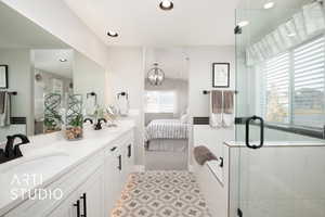 Bathroom with a shower with door, vanity, and an inviting chandelier