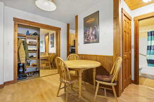 Dining area featuring light wood-type flooring and wooden walls