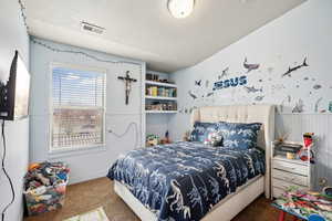 Bedroom featuring carpet and a textured ceiling