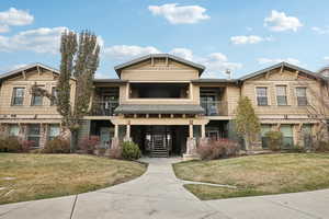 View of front of home featuring a balcony and a front lawn