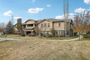 View of front of home with central AC and a front yard