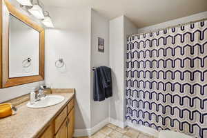 Bathroom featuring a shower with curtain, vanity, and toilet