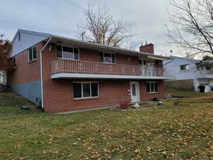 Front view of property with a lawn and a balcony