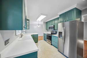 Kitchen featuring pendant lighting, crown molding, sink, light wood-type flooring, and stainless steel appliances