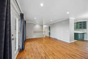 Spare room with light hardwood / wood-style floors and crown molding