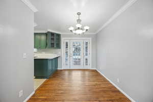 Interior space featuring hardwood / wood-style flooring, a notable chandelier, and crown molding