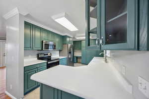 Kitchen featuring kitchen peninsula, sink, stainless steel appliances, and light hardwood / wood-style floors