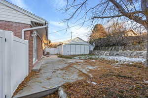 Snowy back yard with a patio area and an outbuilding