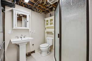 Bathroom with tile patterned floors, toilet, and sink