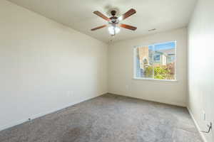 Unfurnished room with ceiling fan and light colored carpet