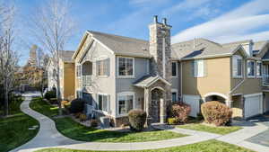 View of front of home with a front lawn, central AC unit, and a garage