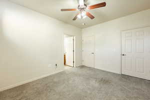 Unfurnished bedroom with ceiling fan and light carpet