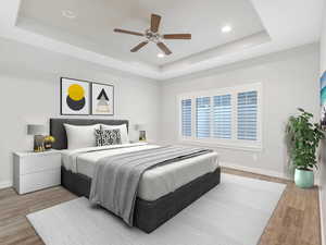 Bedroom featuring hardwood / wood-style flooring, a raised ceiling, and ceiling fan