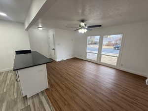 Unfurnished living room with ceiling fan and light hardwood / wood-style floors